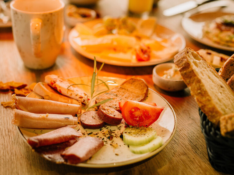 Das reichhaltige Angebot eines Brotzeittellers mit Speck, Gemüse und Käse.