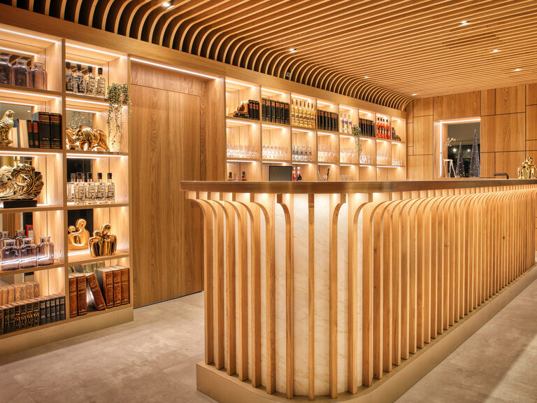 Designer Lifestyle-Bar aus hellen Holz mit angenehmen Lichtakzenten im Hotel Kronberg in Bodenmais.