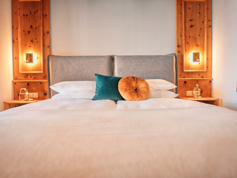 Gemütliches Bett im Hotel das Kronberg mit stimmungsvollen Ambientelicht.