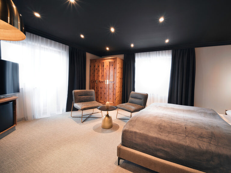 Ein geräumiges Schlafzimmer mit einem großen Bett und einem Flachbildfernseher im Doppelzimmer.