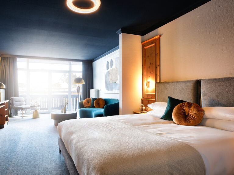 Ein helles Hotelzimmer mit einem großen Bett und Sitzgelegenheiten bietet komfortable Unterkunft.