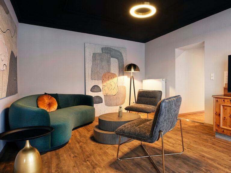 Helle und morderne Sitzgelegenheit mit gemütlichen Sofa im Doppelzimmer.