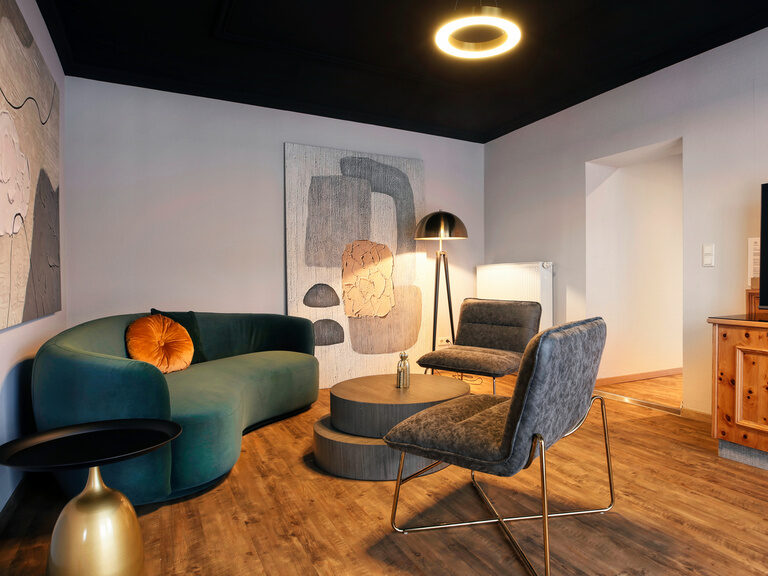 Ein elegant eingerichtetes Wohnzimmer im Hotel Kronberg mit einem Flachbildfernseher.