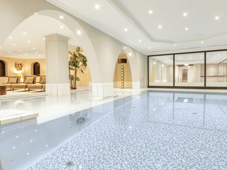 Einladendes Schwimmbad mit hellblauen Wasser im Adults only Hotel Kronberg in Bodenmais.