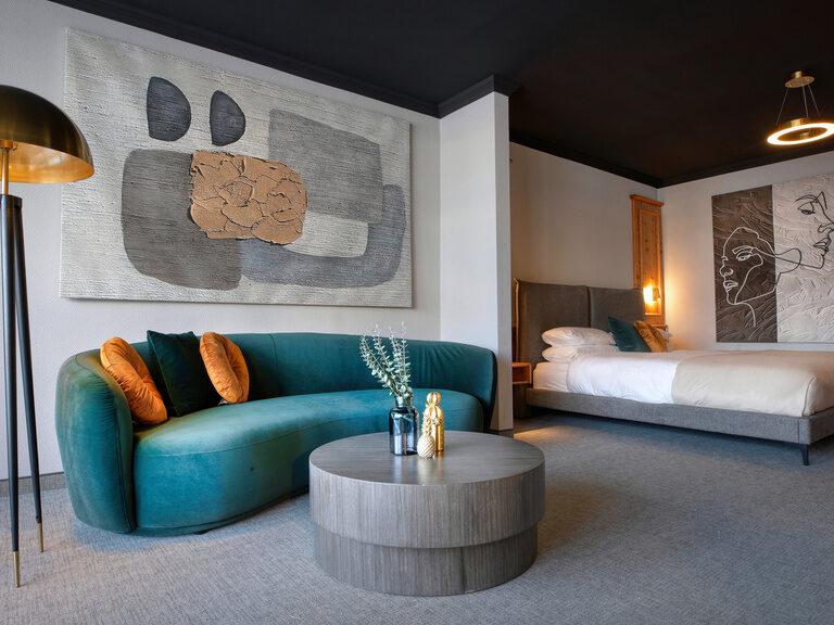 Ein stilvolles Doppelzimmer im Hotel Kronberg mit einer gemütlichen Couch und einem eleganten Couchtisch.